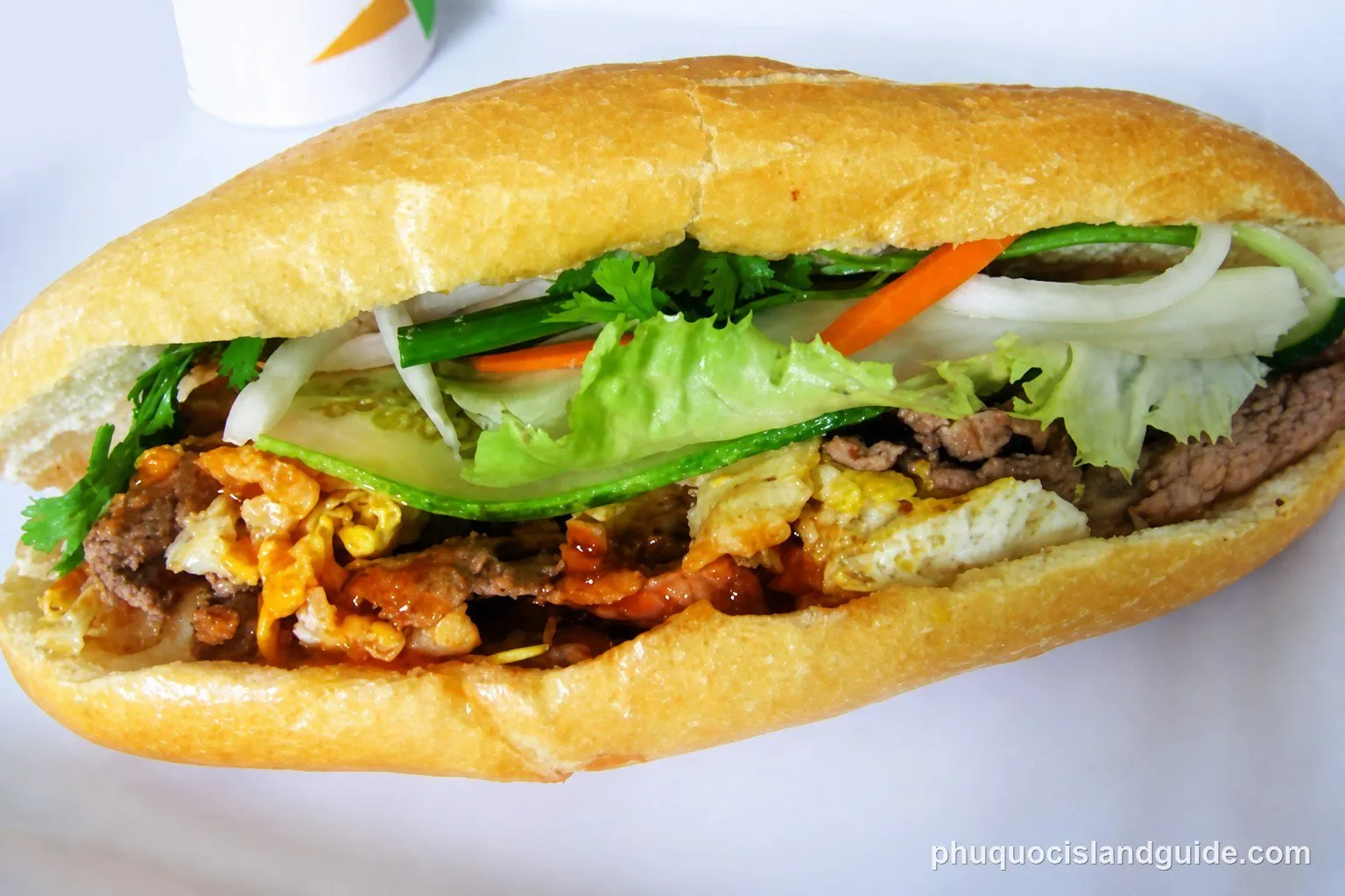 Bánh mì filled with meat, vegetables and fried egg