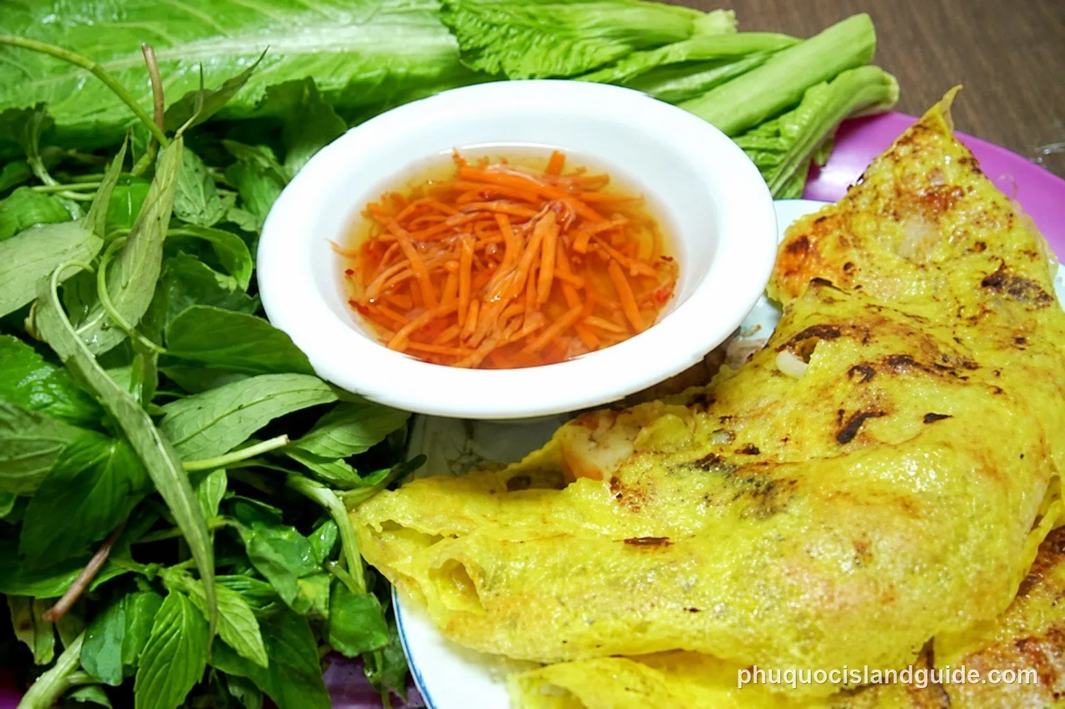 Bánh xèo pancakes with fresh herbs and dipping sauce