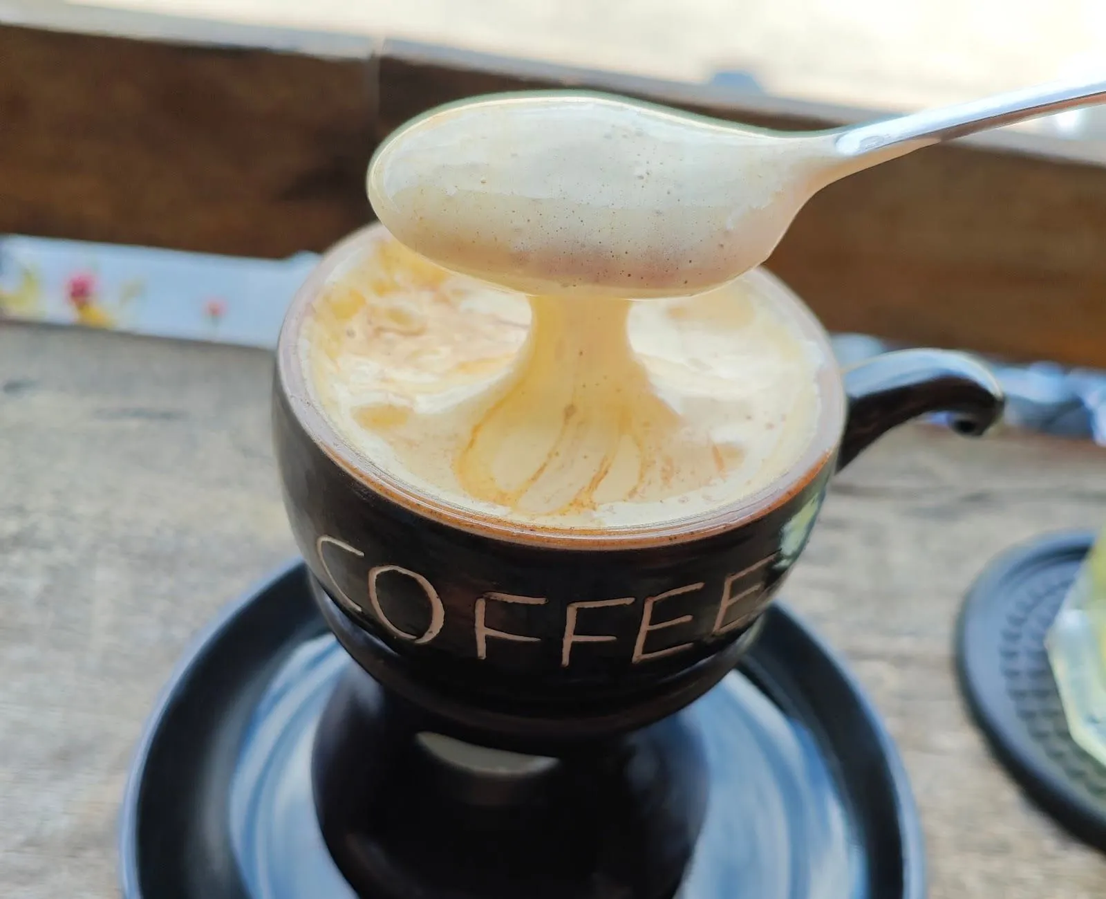 Egg coffee being lifted with a spoon at Hi Coffee, Phu Quoc