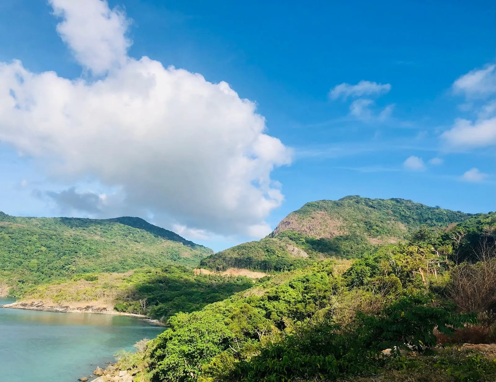 Forested hills dropping to a turquoise bay on Con Son island, Con Dao