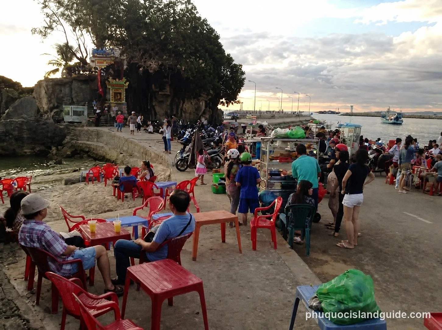 Evening crowds at plastic tables below Dinh Cau rock temple, Duong Dong