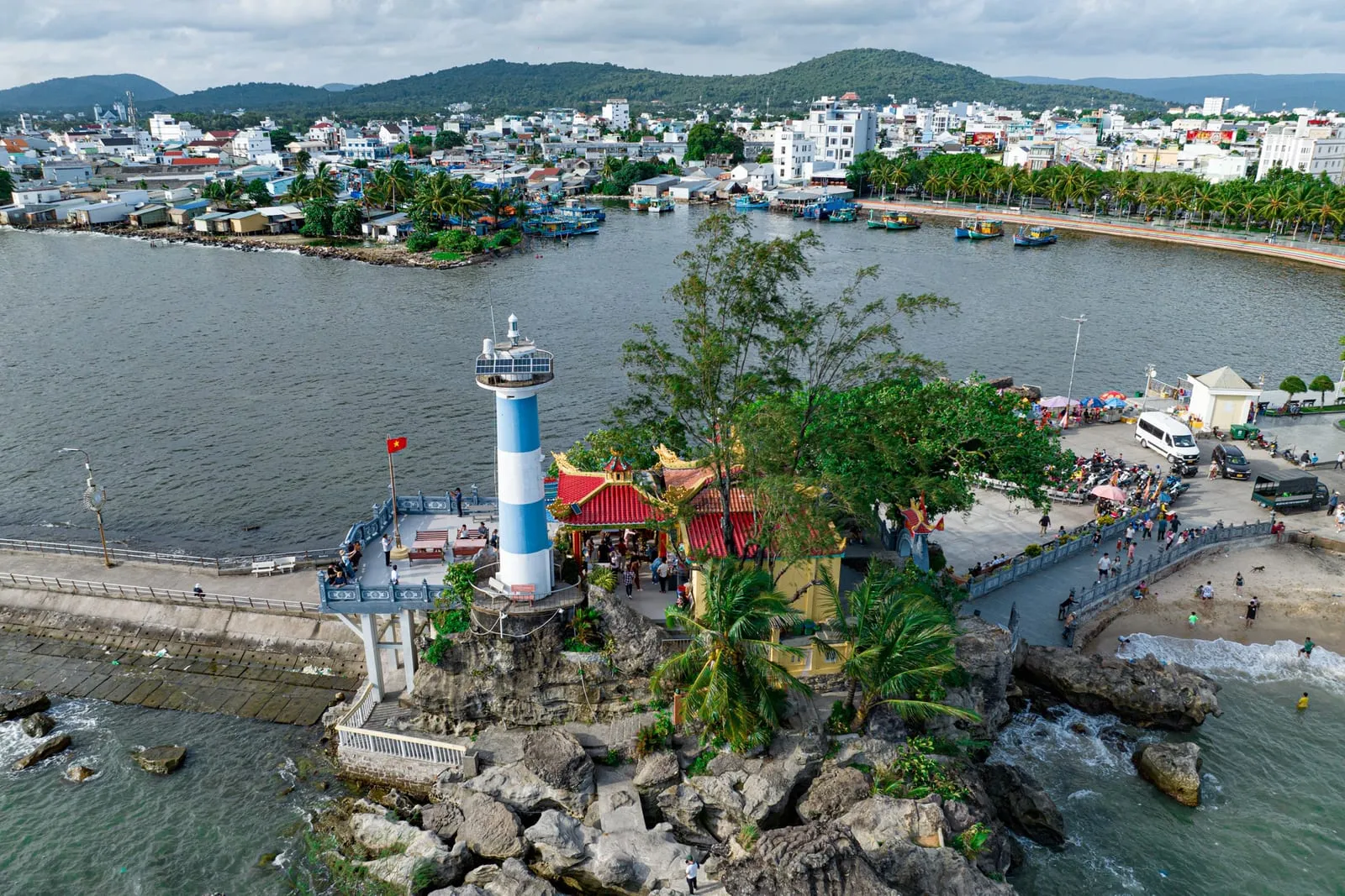 Aerial view of Dinh Cau lighthouse and temple at the mouth of the Duong Dong River, with the town behind