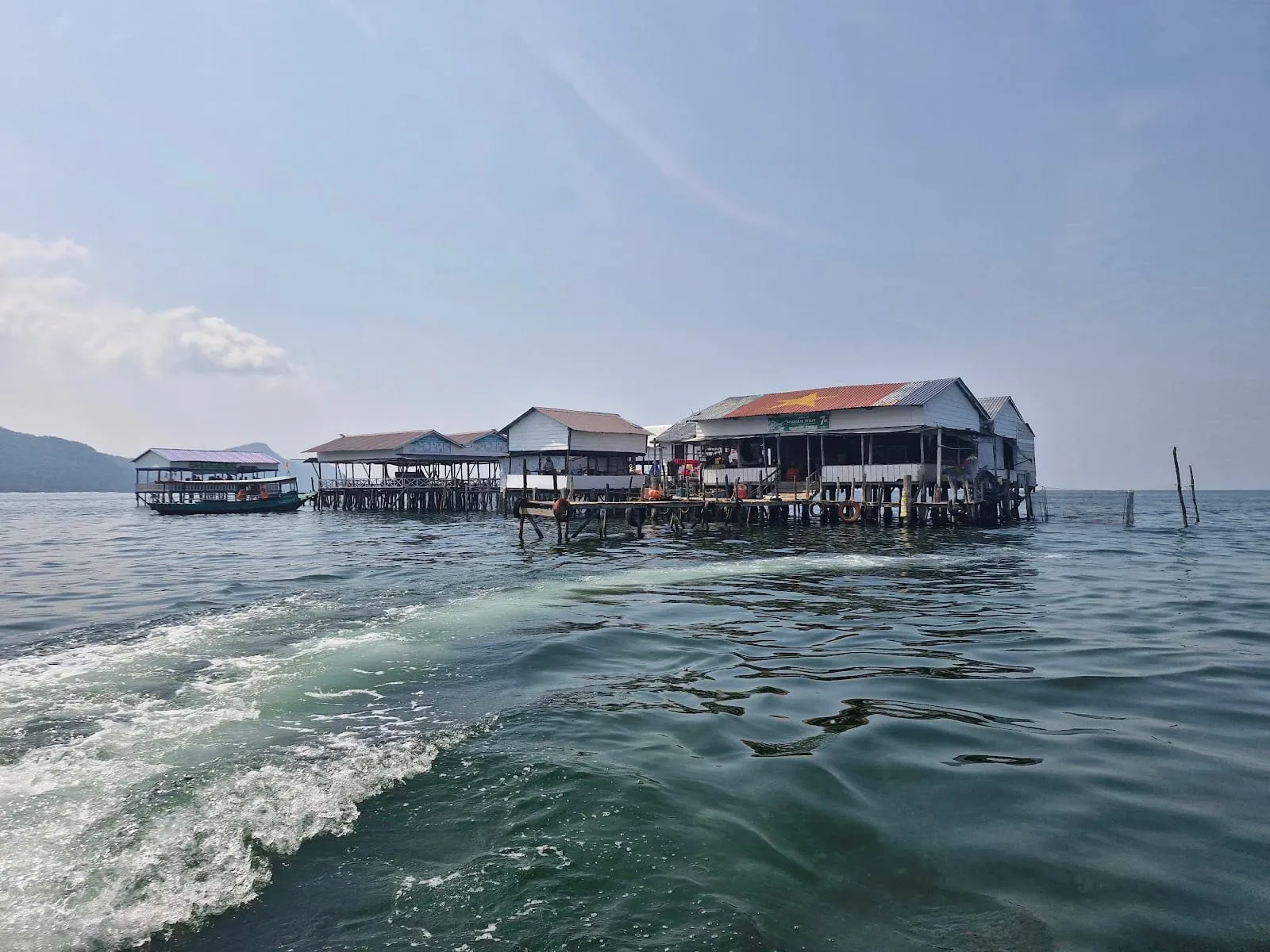 Stilt seafood restaurants over the sea at Rach Vem, seen from a boat
