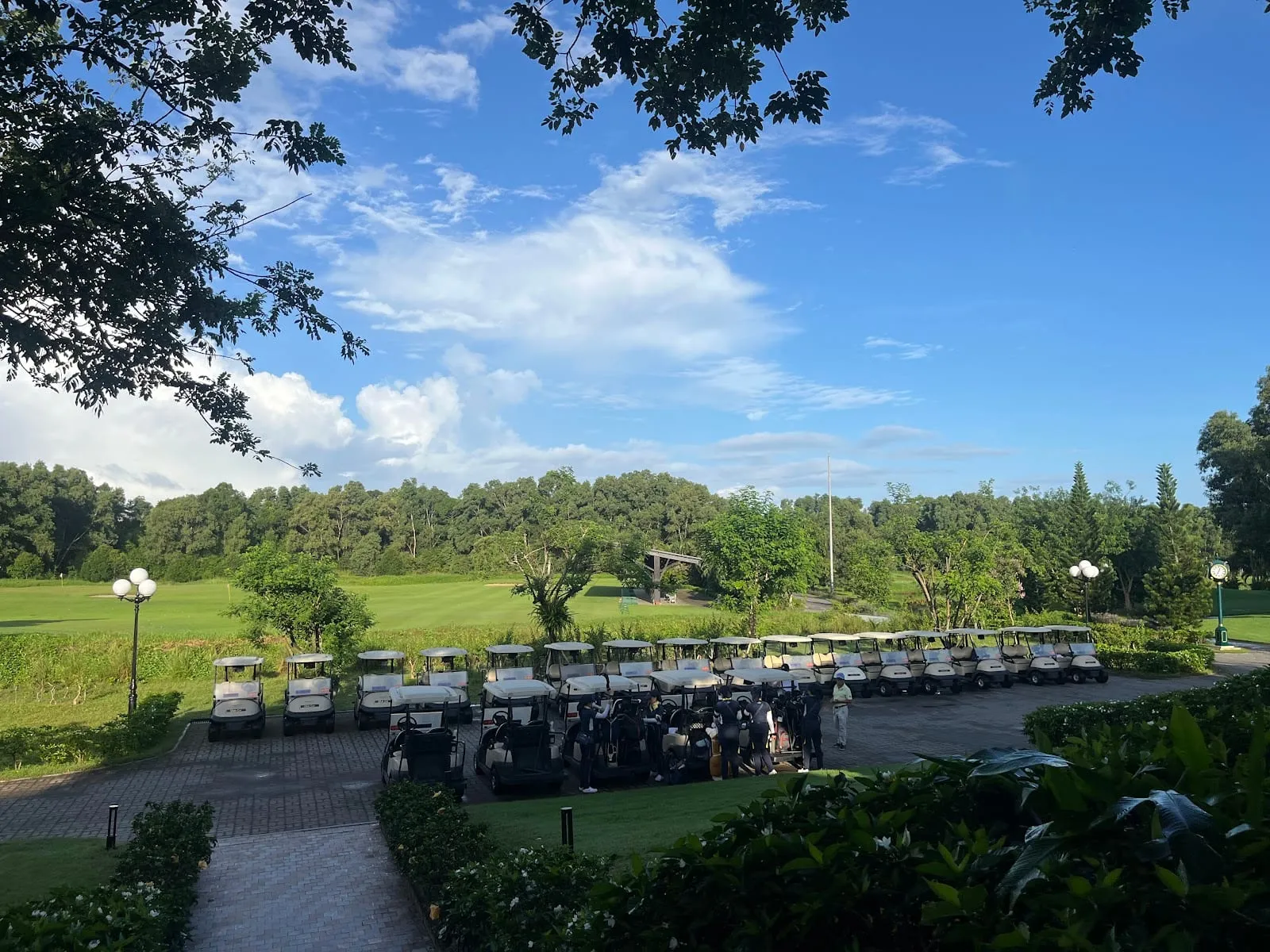 Golf buggies lined up beside the clubhouse among trees at Vinpearl Golf Phu Quoc