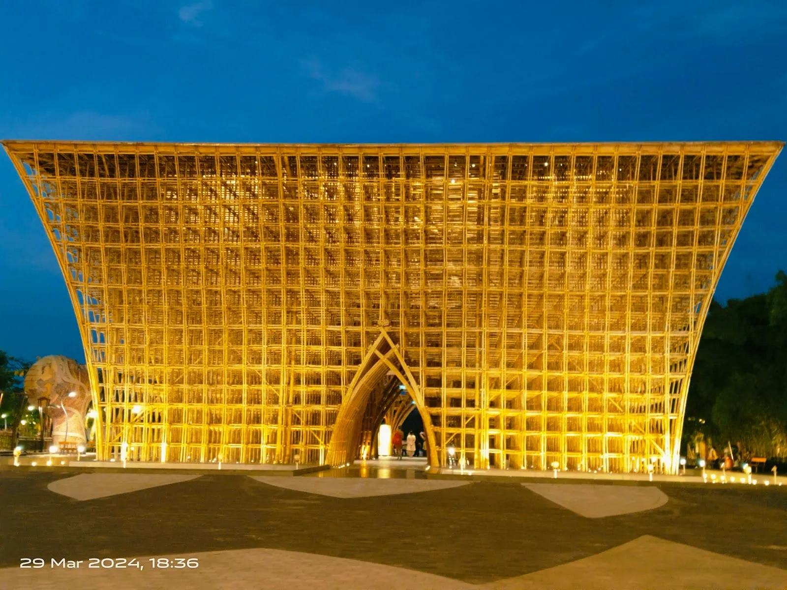 The giant bamboo Bamboo Legend structure at Grand World lit up in gold at dusk