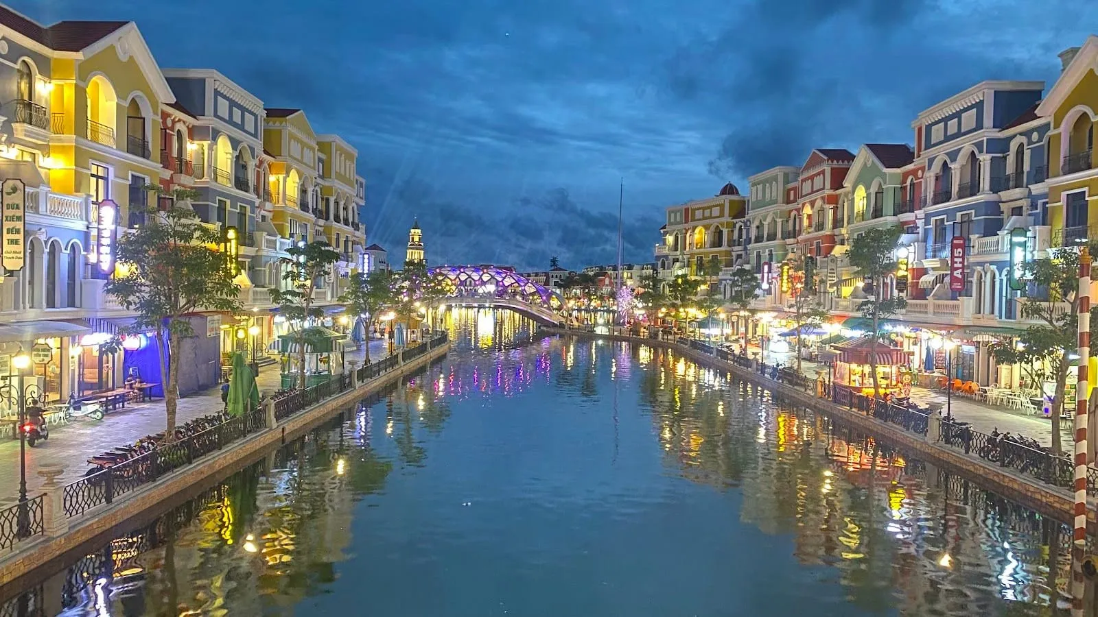 The Venice-style canal at Grand World Phu Quoc lit up at dusk, with colourful buildings on both banks