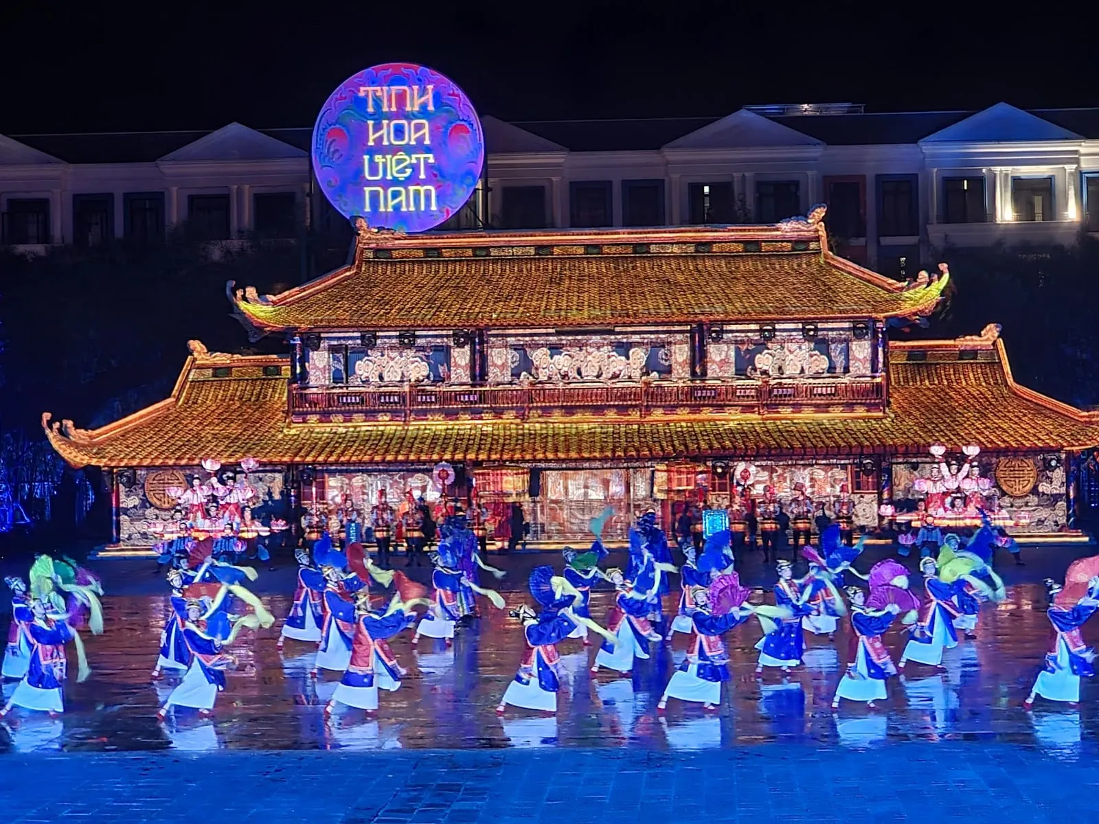 The illuminated stage of the Tinh Hoa Viet Nam show, with dancers in front of a traditional palace set