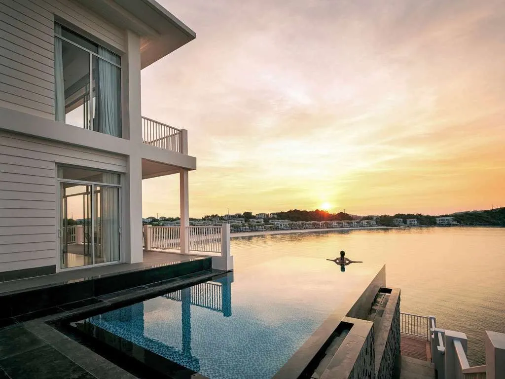A villa with a private pool beside the sea at Premier Village, at sunset