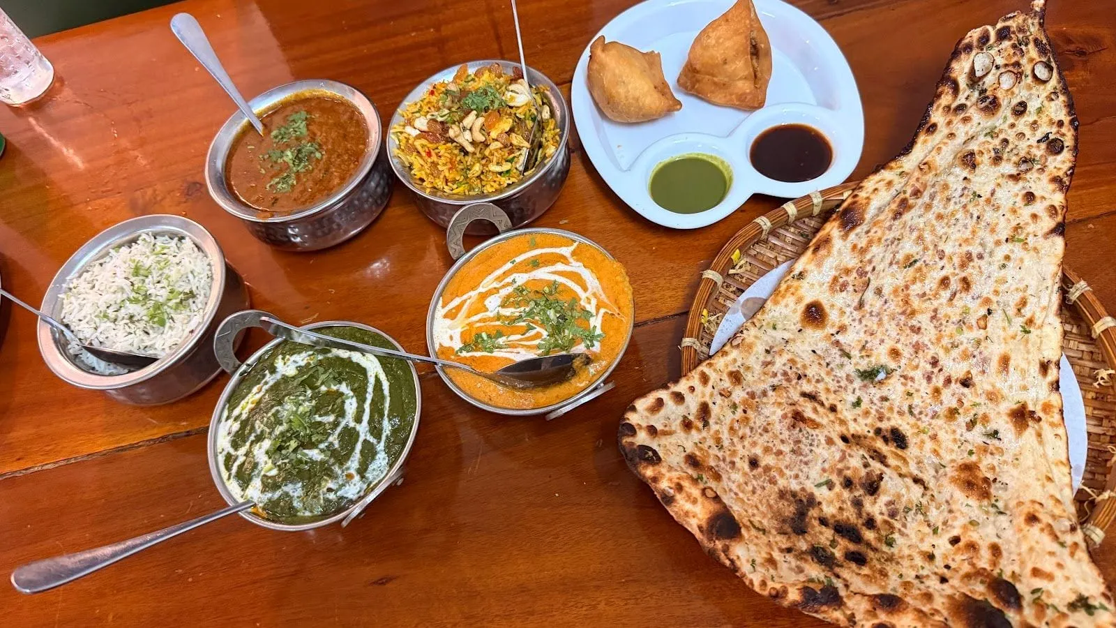 A table of Indian dishes with curries, naan and samosas at a vegetarian restaurant in Duong Dong
