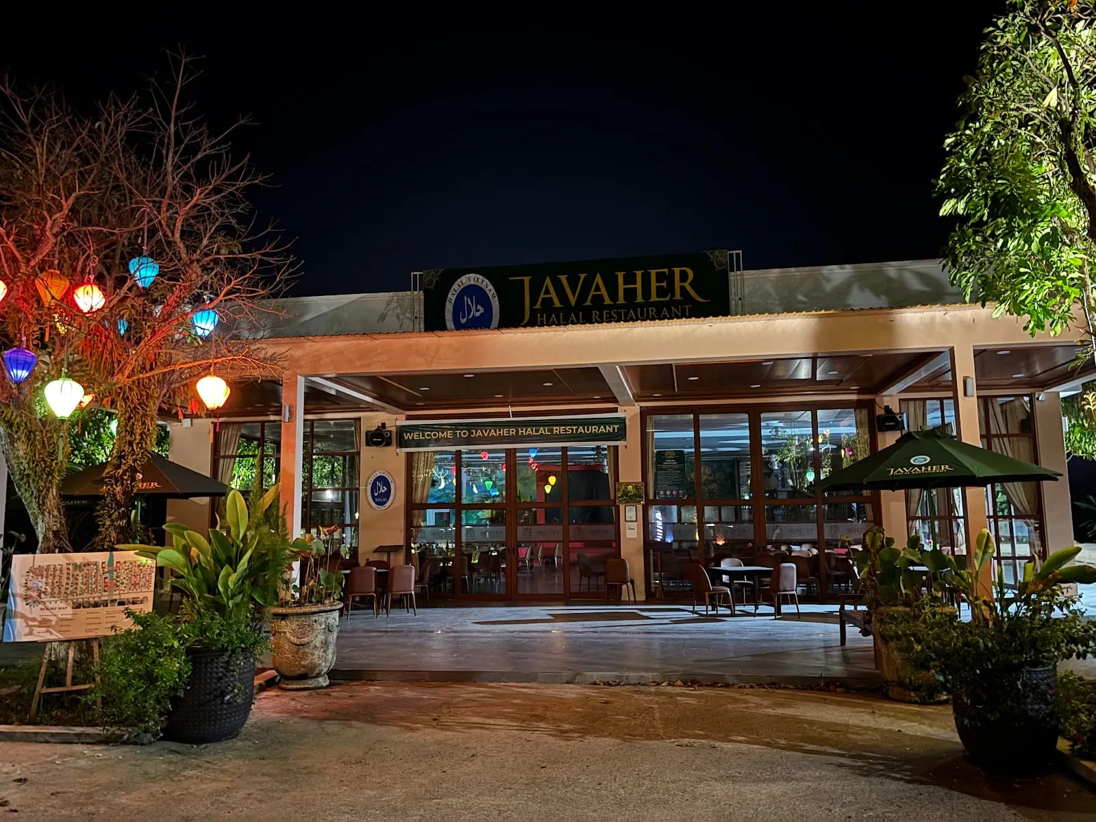 The entrance of Javaher Halal Restaurant lit up at night