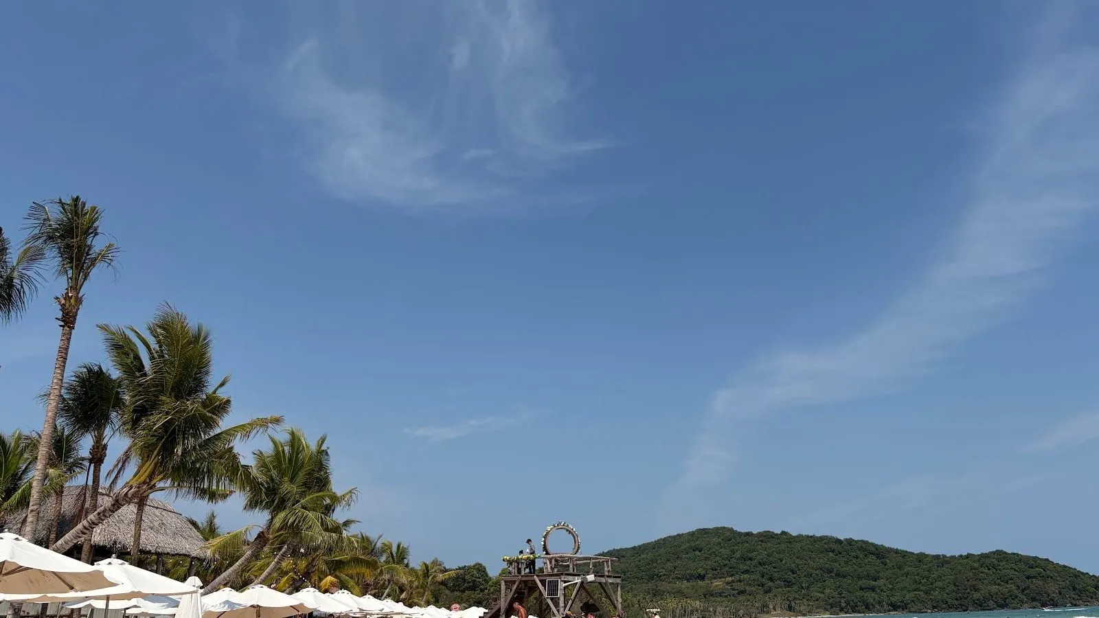 A rope swing on a palm-lined white-sand beach at Sao Beach under a blue sky in March