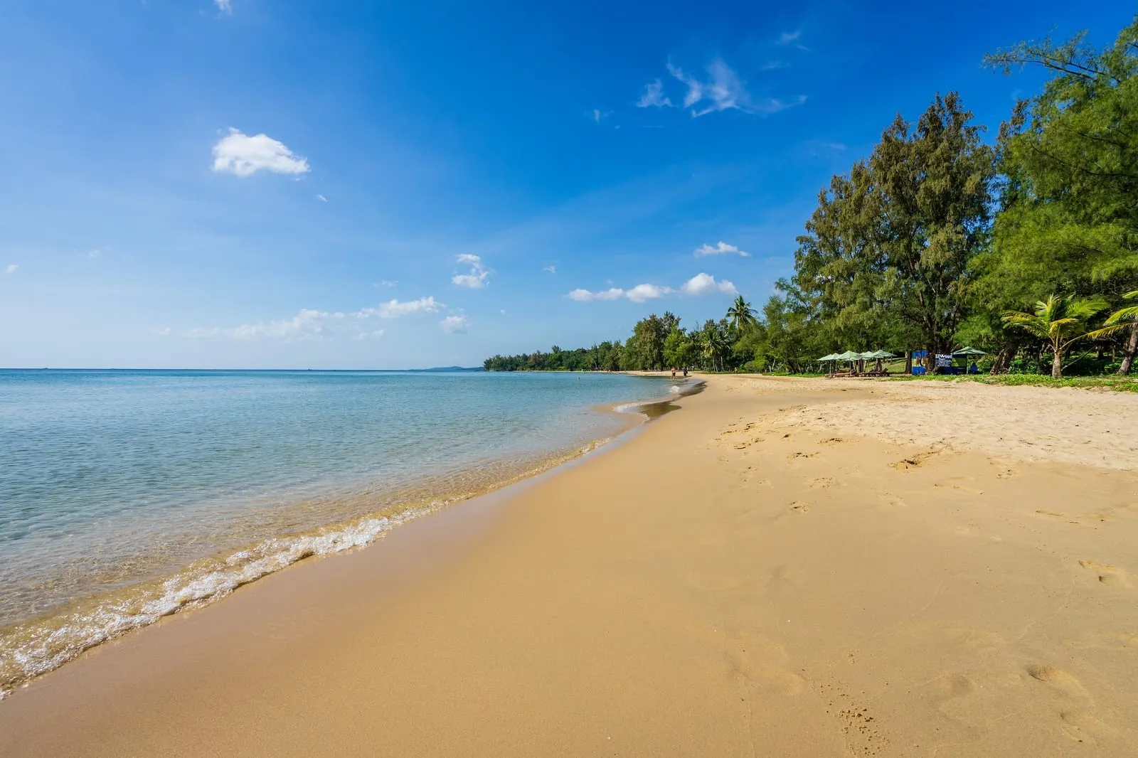 The sandy curve of Ong Lang Beach under a blue sky