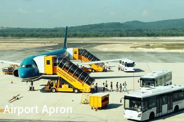 The apron and tarmac at Phu Quoc International Airport, with aircraft parked at remote stands and jungle-covered hills behind.