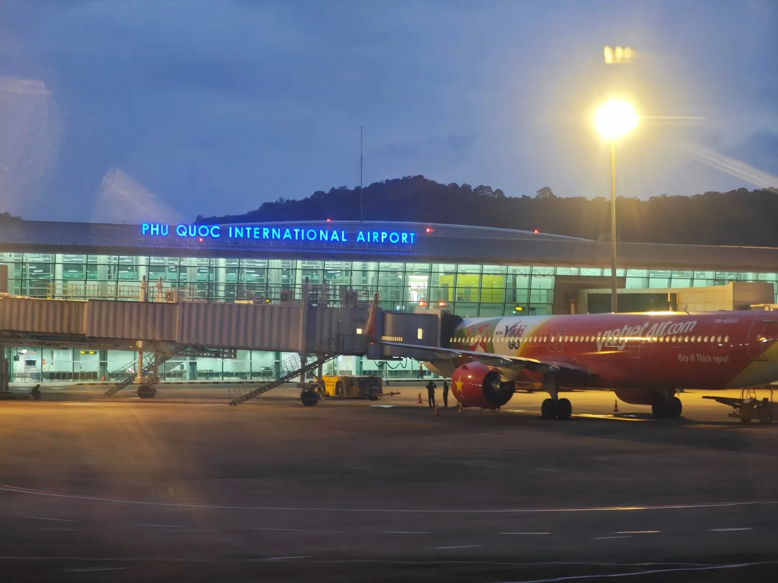 Phu Quoc International Airport terminal at night, with an aircraft at the gate