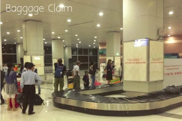 The arrivals area at Phu Quoc International Airport, with the baggage belt, exit doors and passengers collecting luggage.