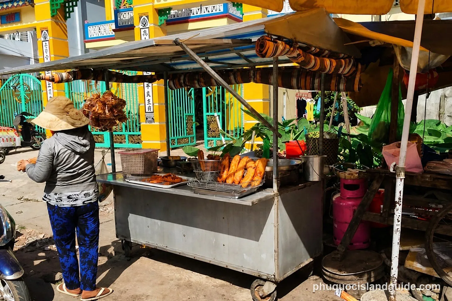 Woman beside a street food cart selling fried snacks