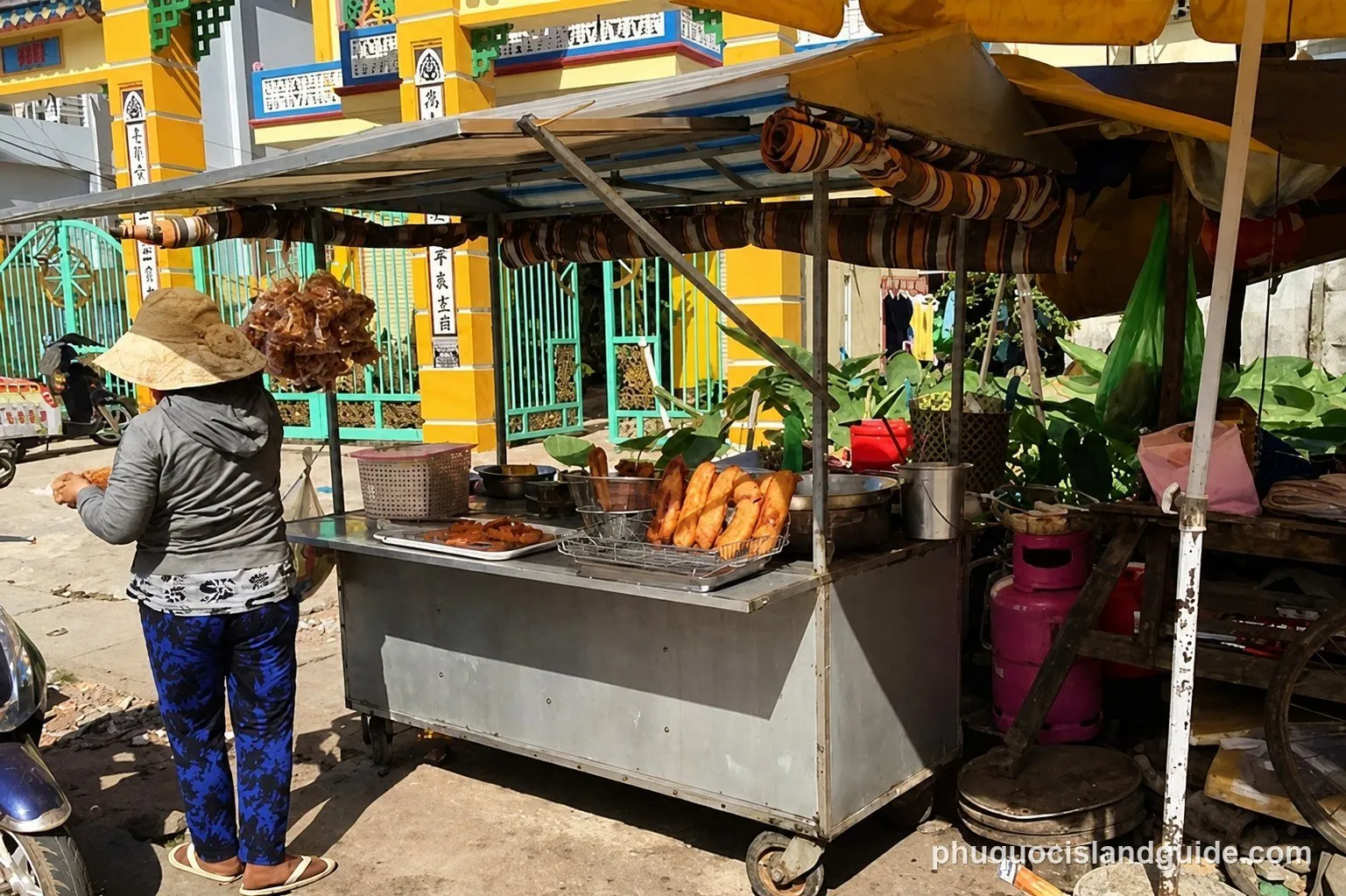 Woman beside a street food cart selling fried snacks