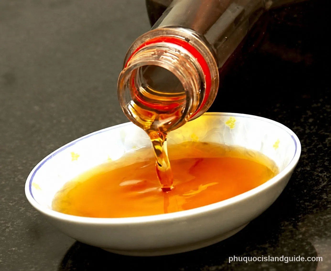 Golden-brown Phu Quoc fish sauce poured into a white bowl