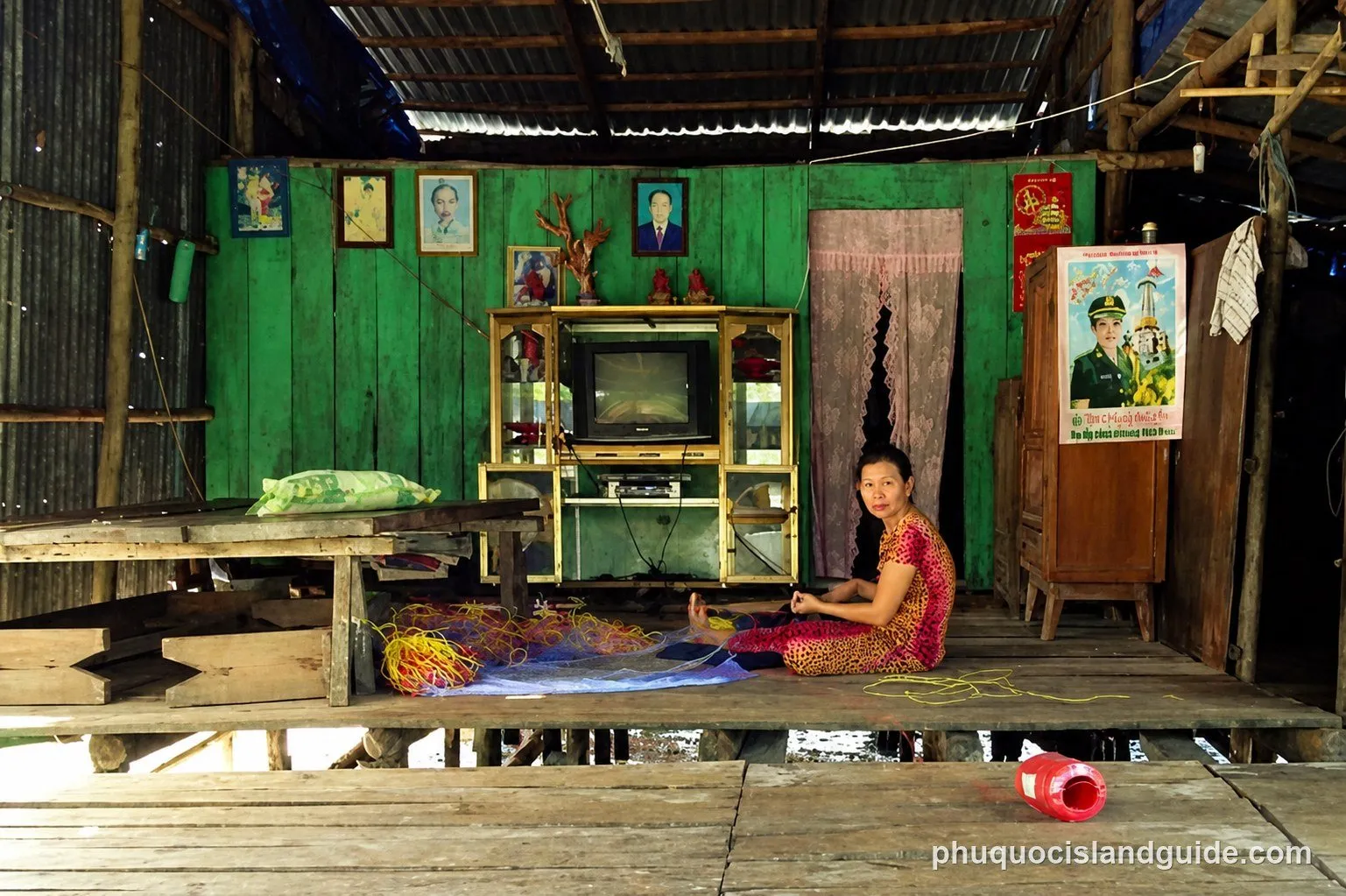 Woman working on the floor of a simple house in Rach Vem