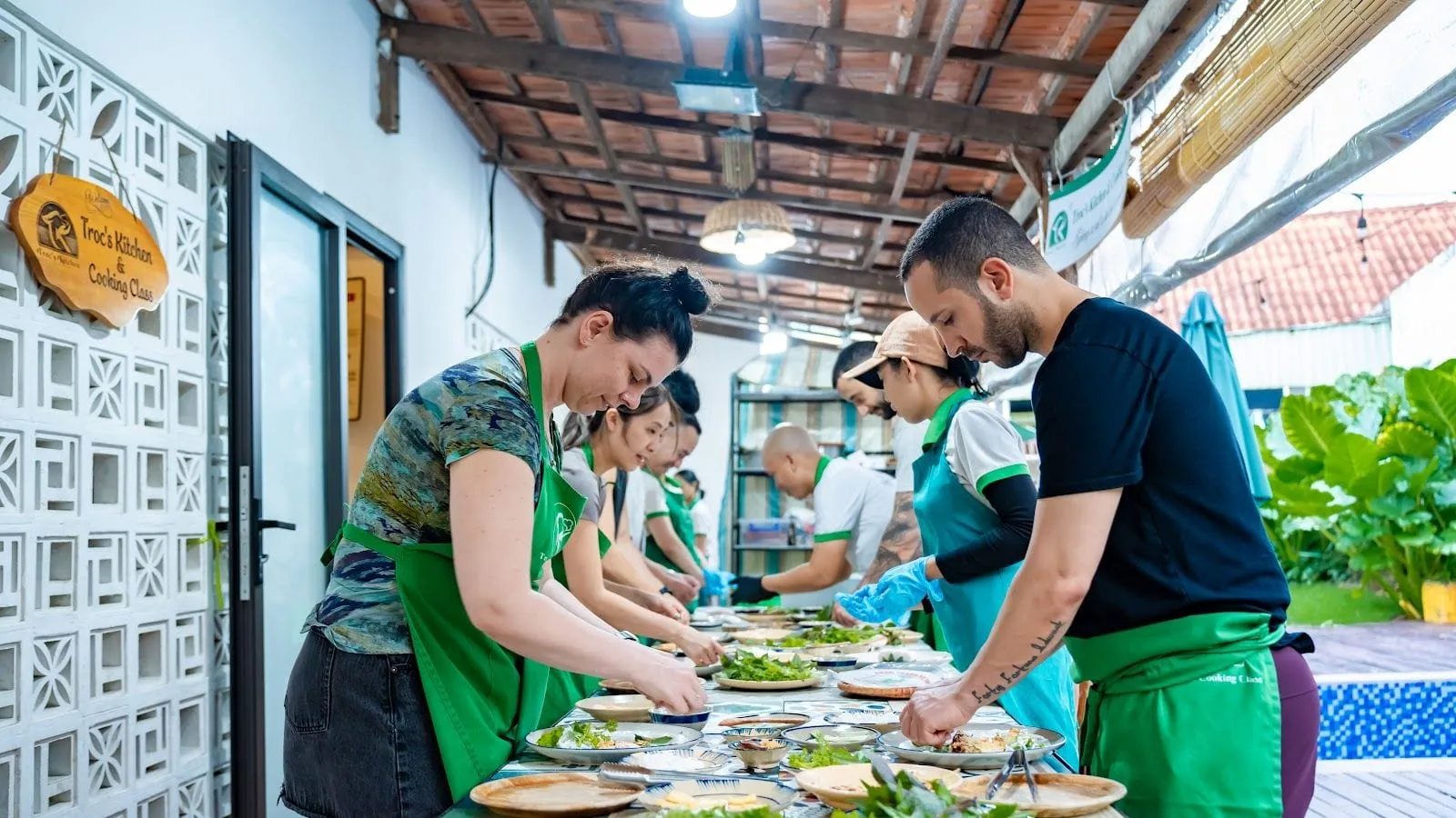 A group cooking together at a long table during a Vietnamese cooking class on Phu Quoc