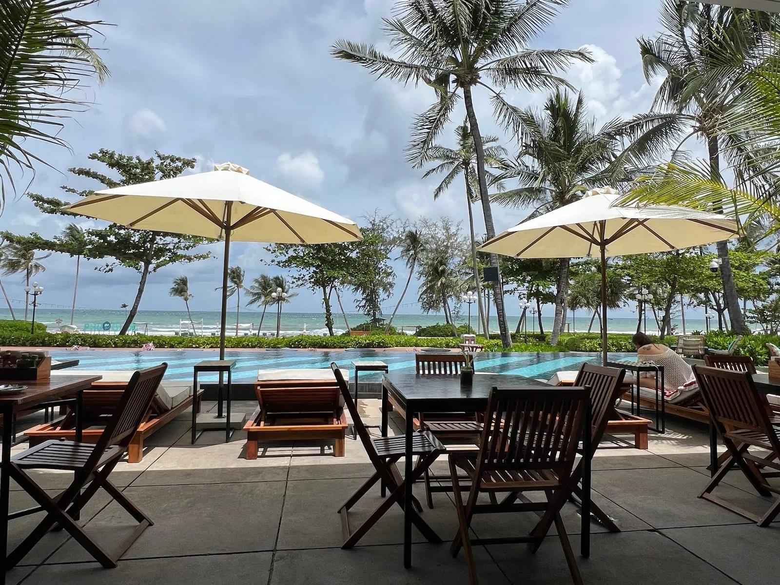 Sunbeds and umbrellas by the pool at Sailing Club, facing Long Beach