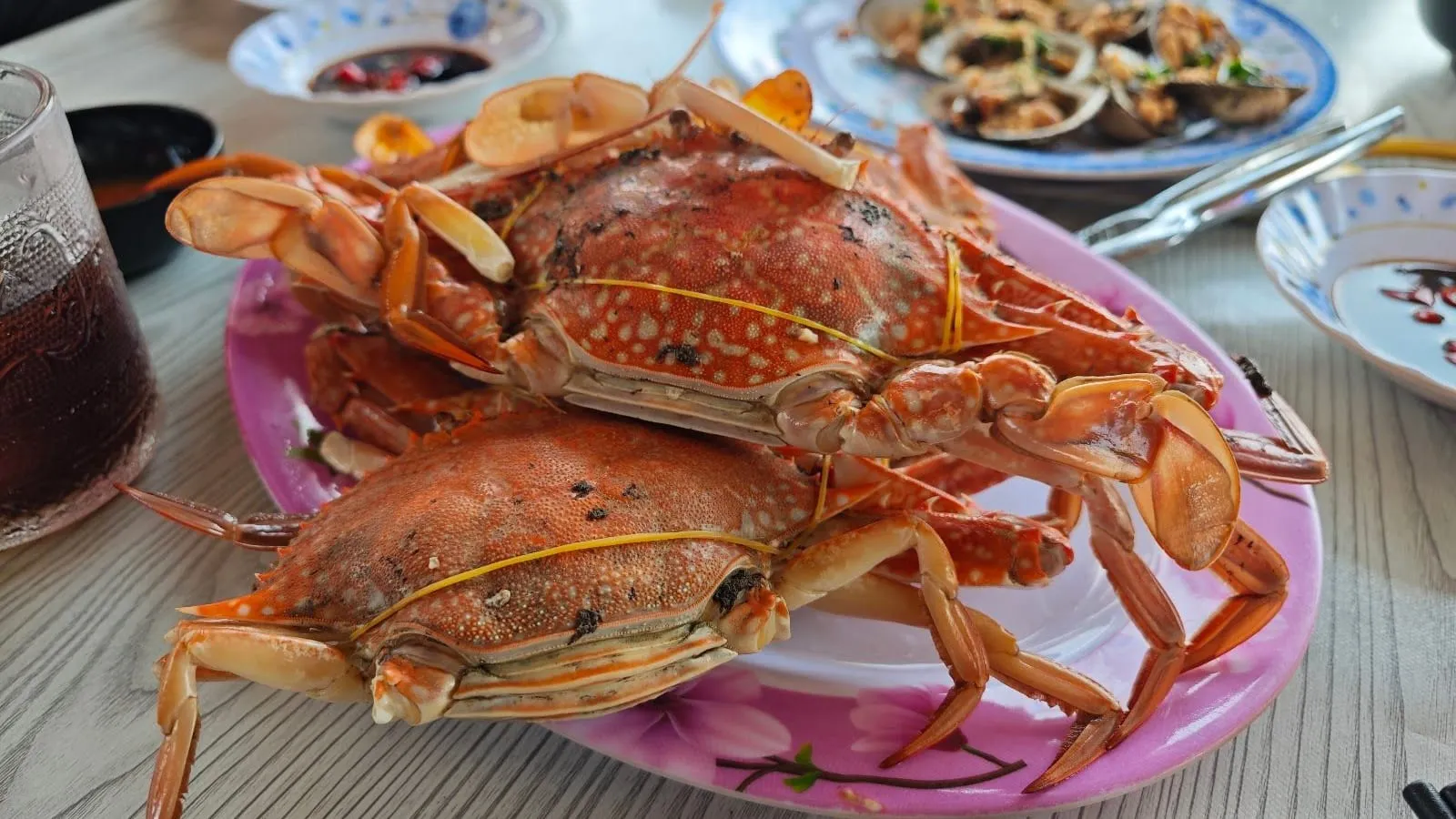Two steamed blue swimmer crabs on a plate at a floating seafood restaurant in Ham Ninh
