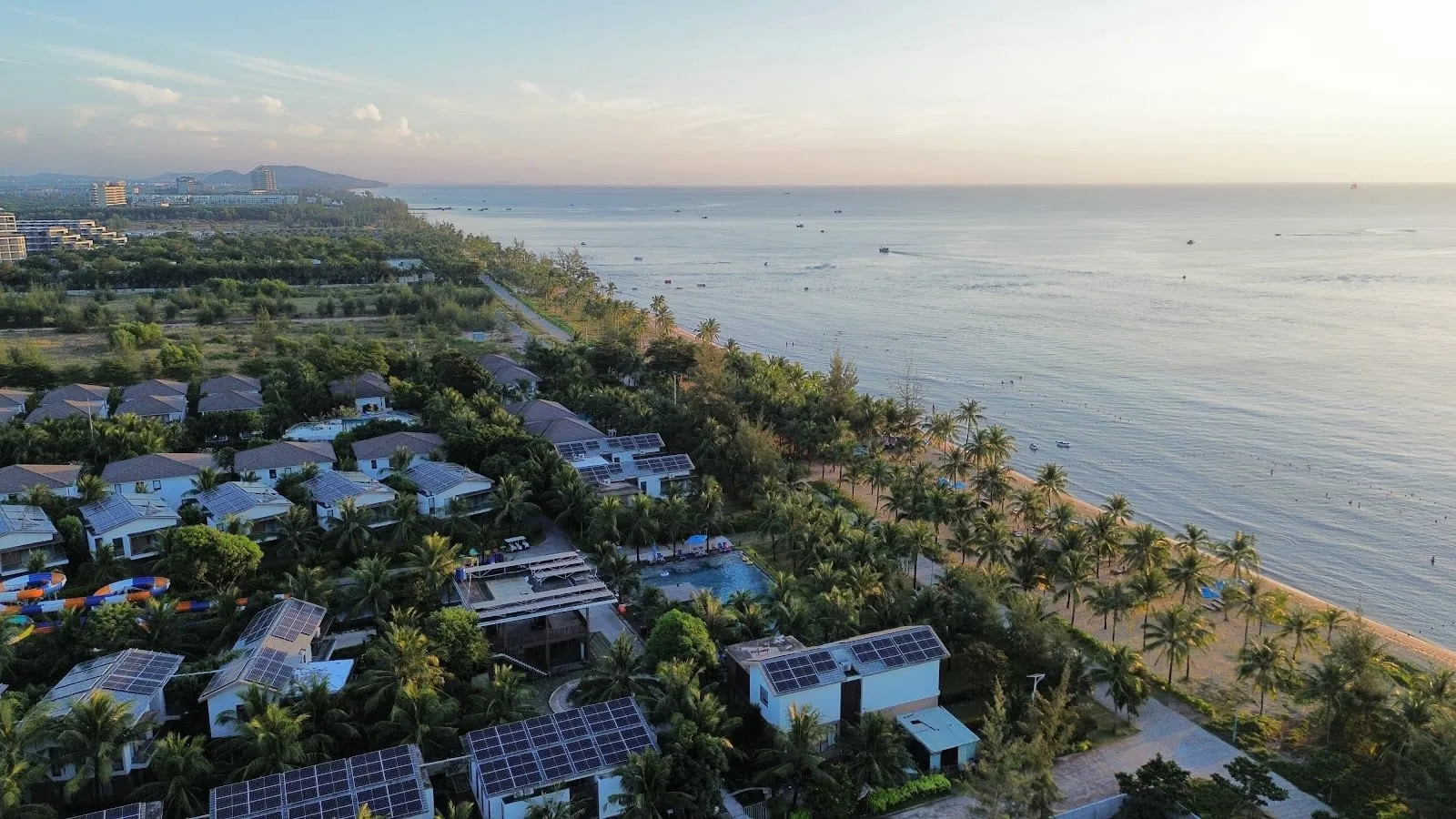 Aerial view of resort villas and palm-lined sand along South Long Beach in the Sonasea area