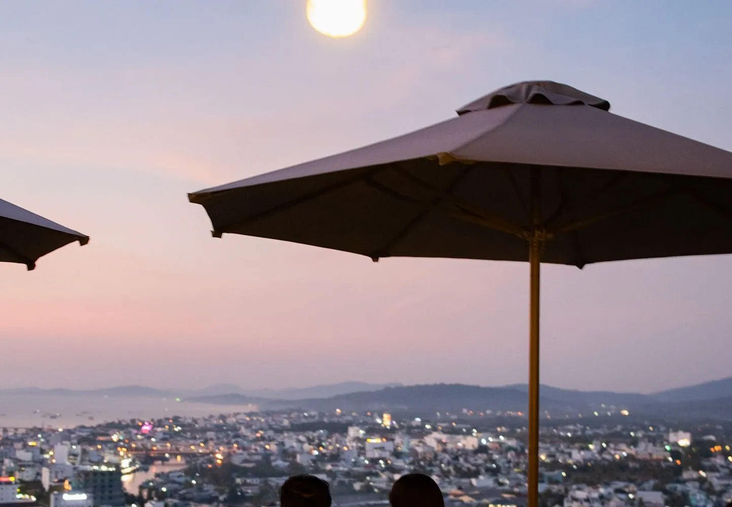The view over the lights of Duong Dong town to the sea at dusk from a hillside terrace
