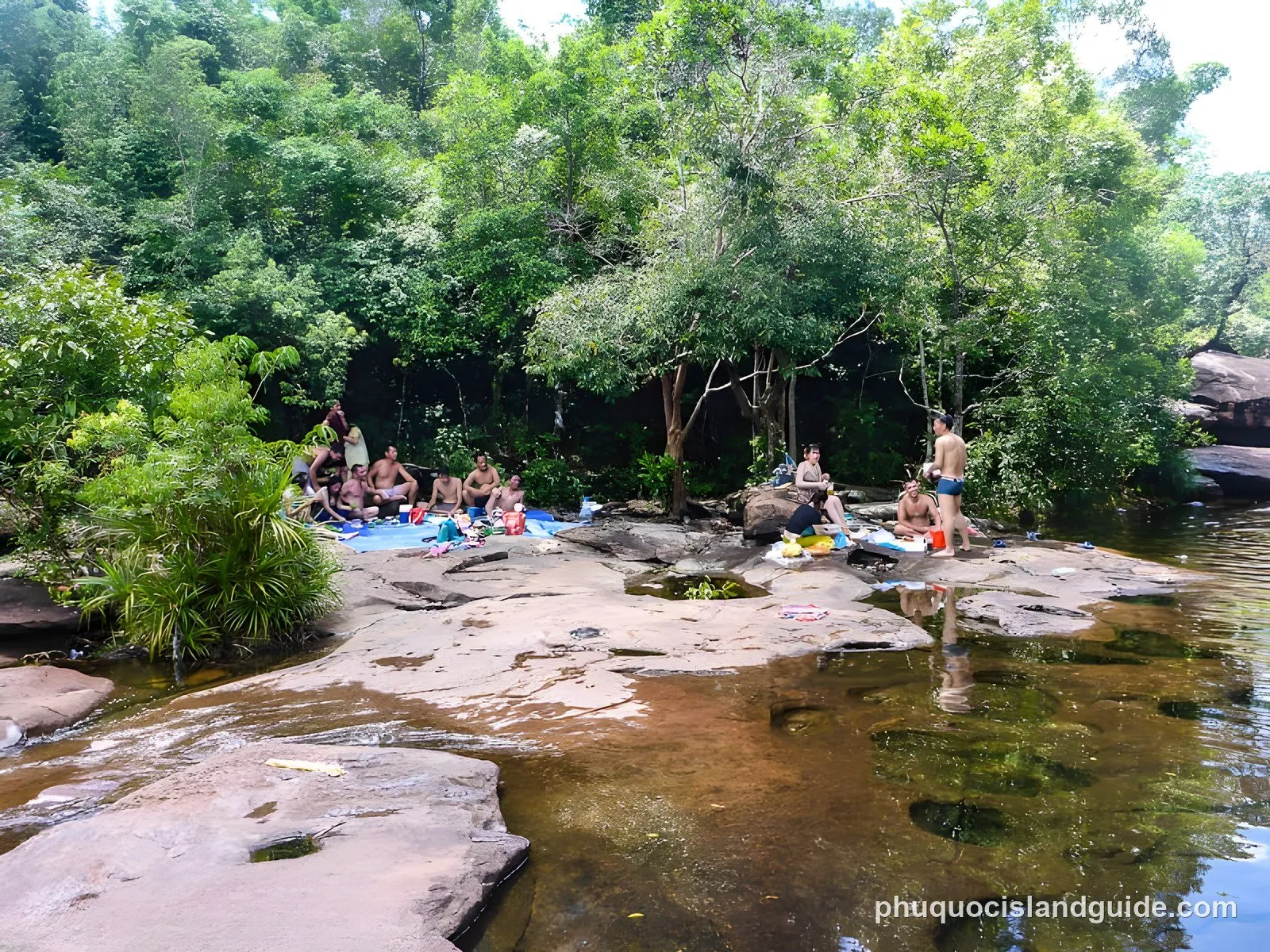 People picnicking on the rocks beside the Da Ban stream