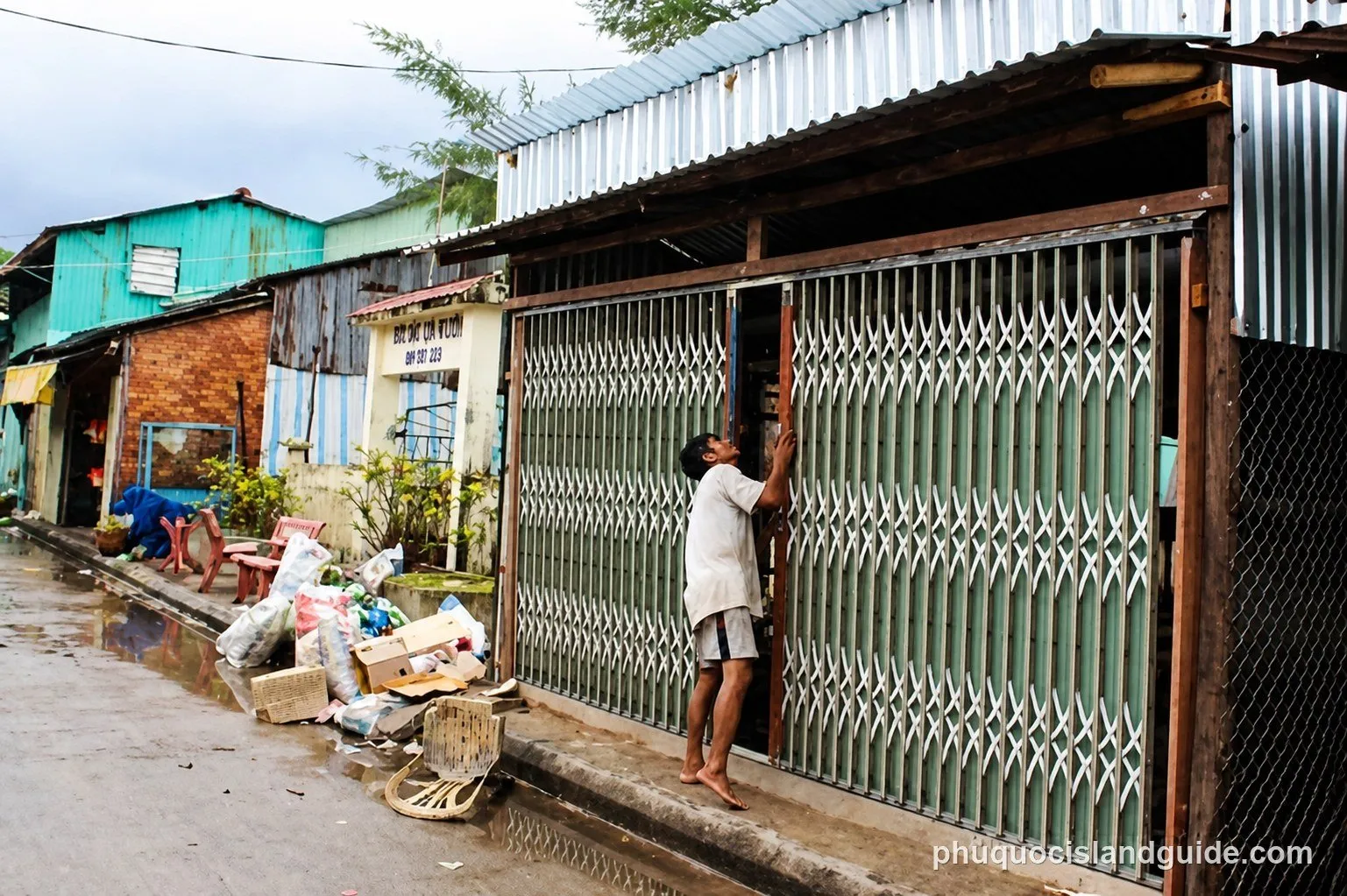 A street of small houses and shops with metal shutters