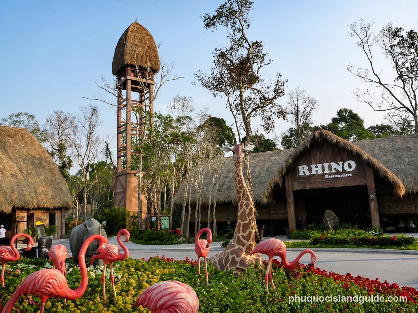 Safari-themed restaurant with a thatched tower and a giraffe statue