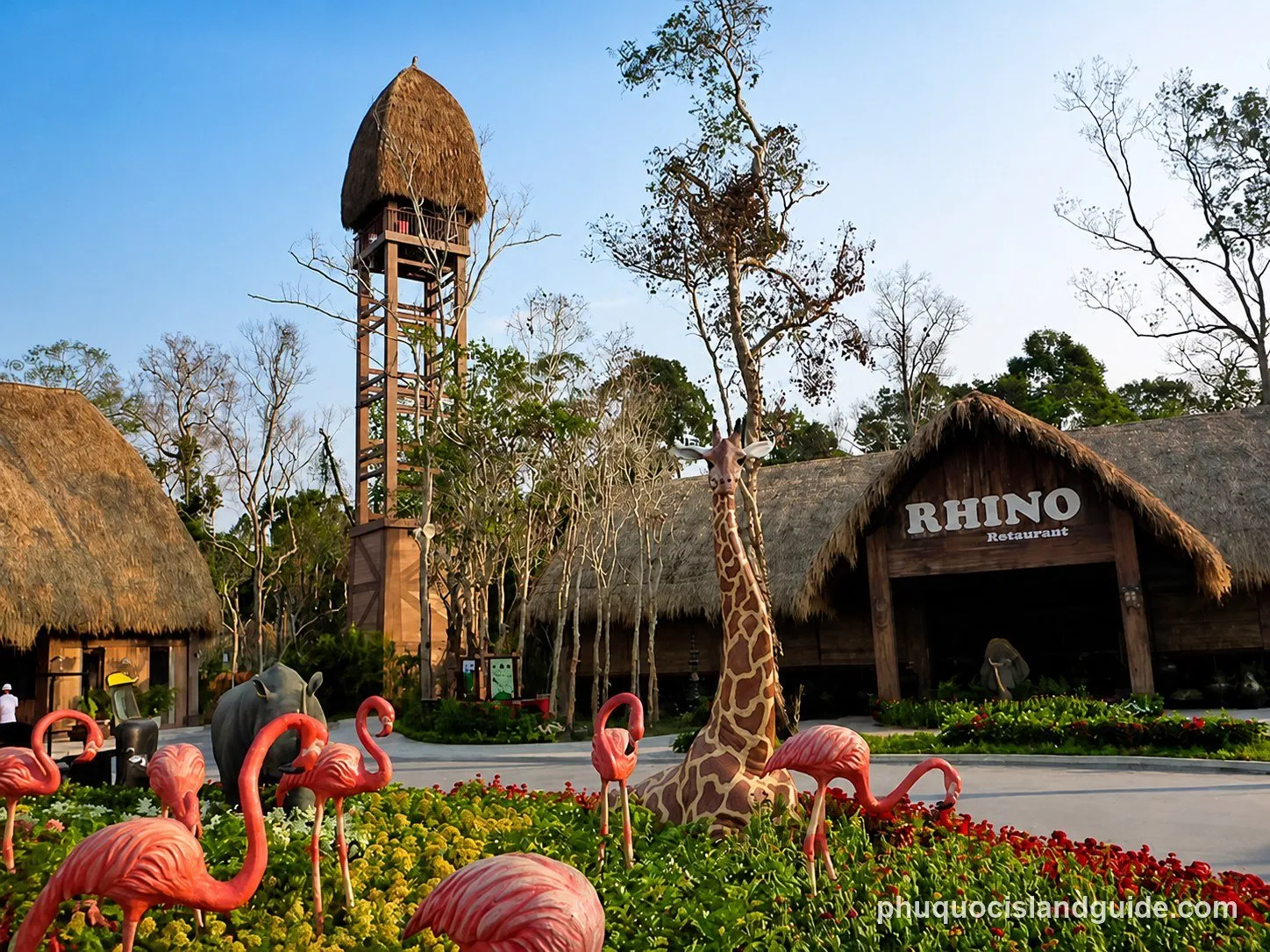 Safari-themed restaurant with a thatched tower and a giraffe statue