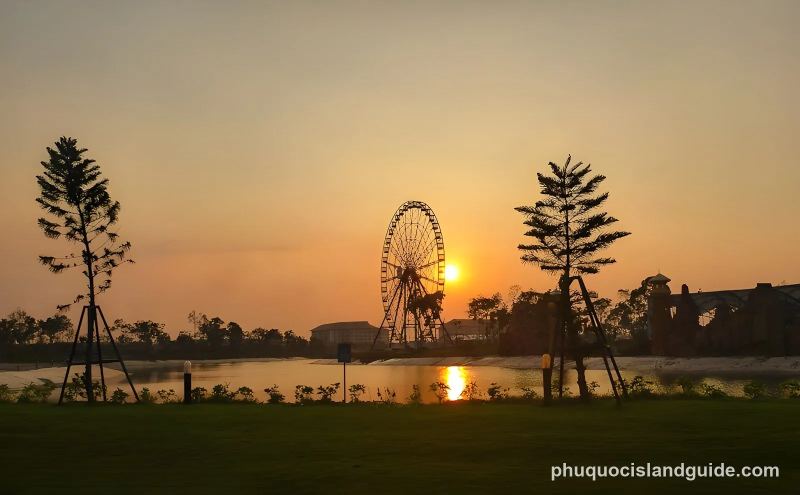 Ferris wheel silhouetted against the sunset over a lake