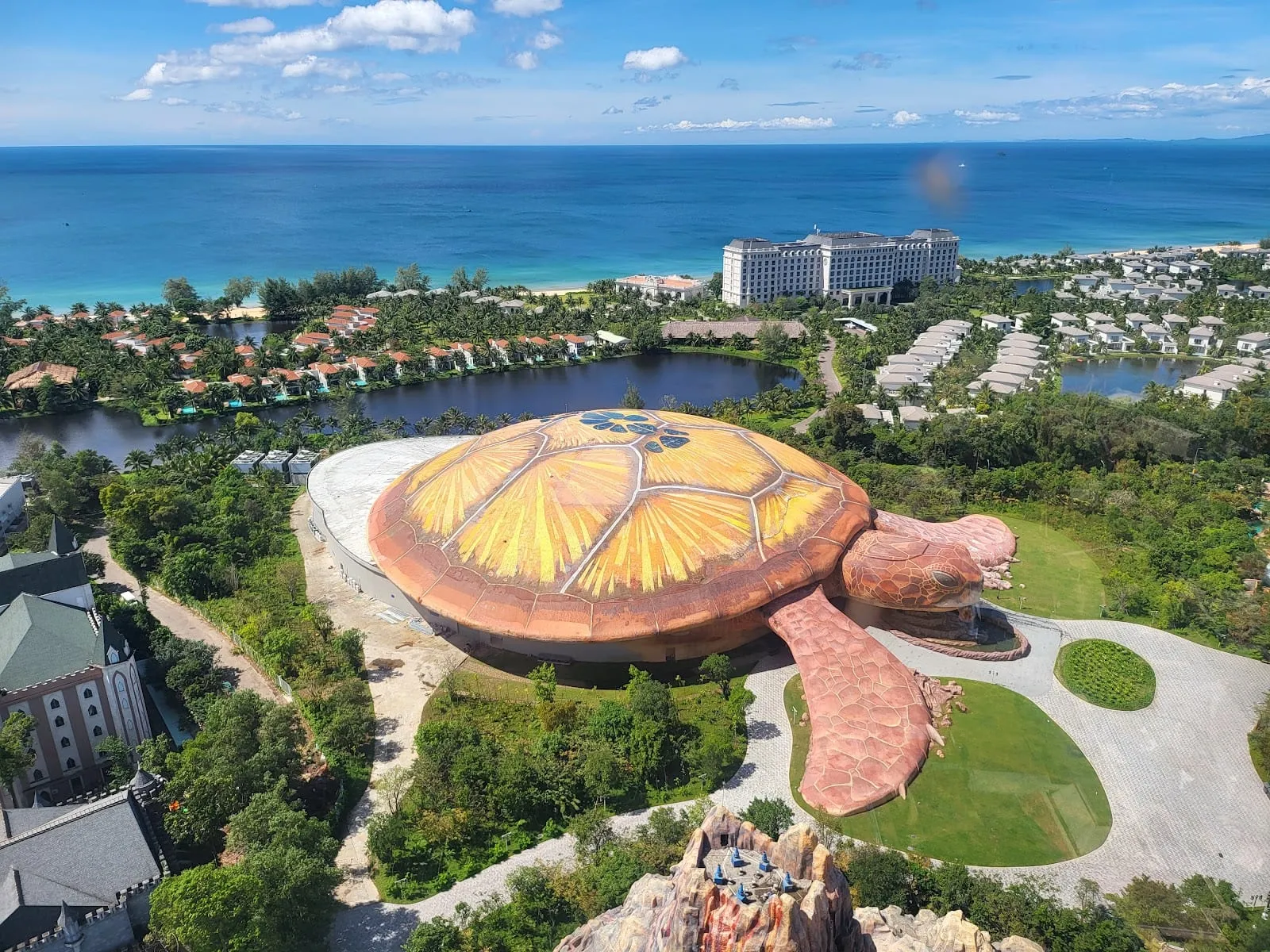 The turtle-shaped Sea Shell aquarium building at VinWonders seen from above, with the sea behind