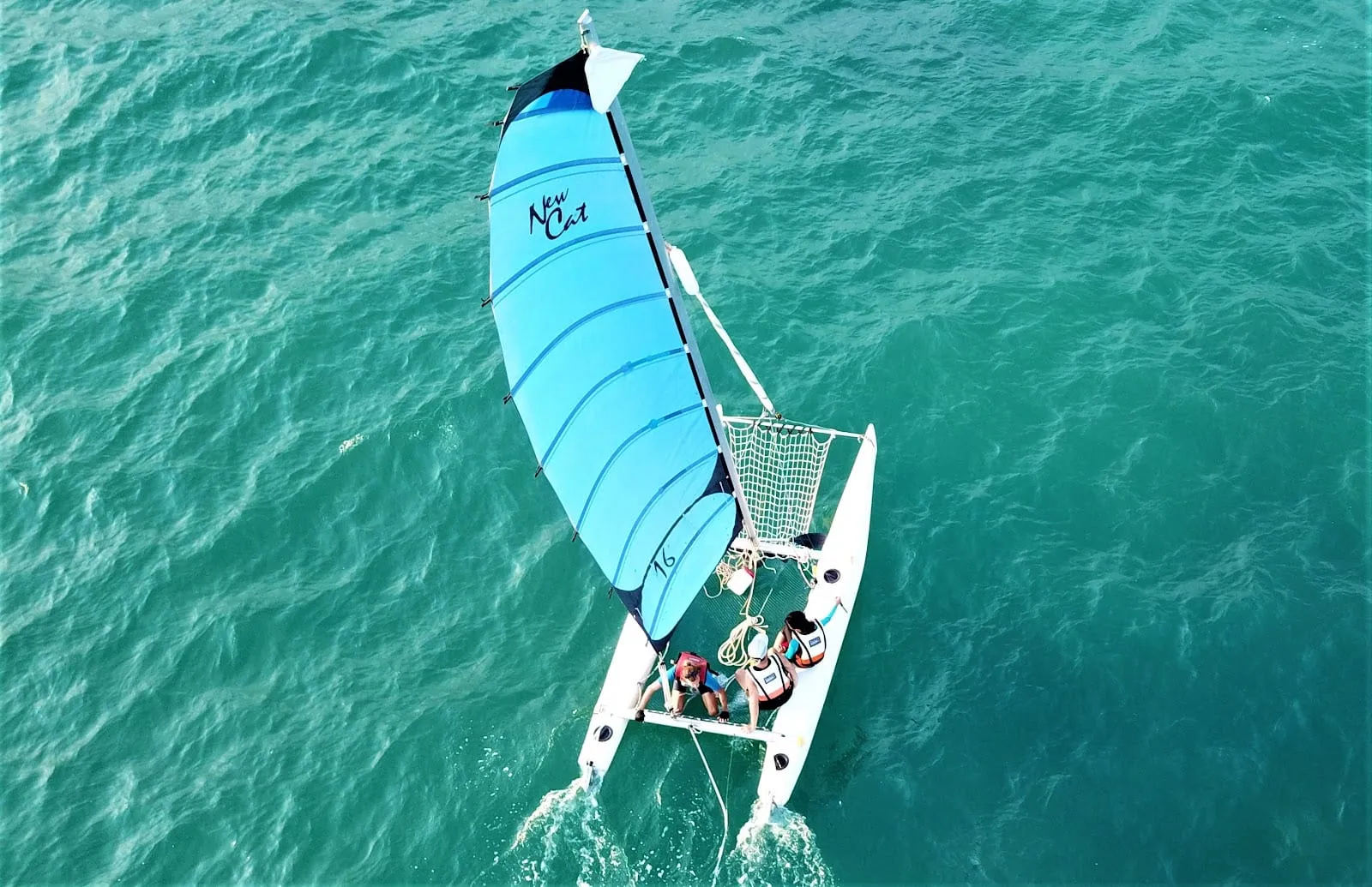 A small sailing catamaran crossing turquoise water off Phu Quoc, seen from above