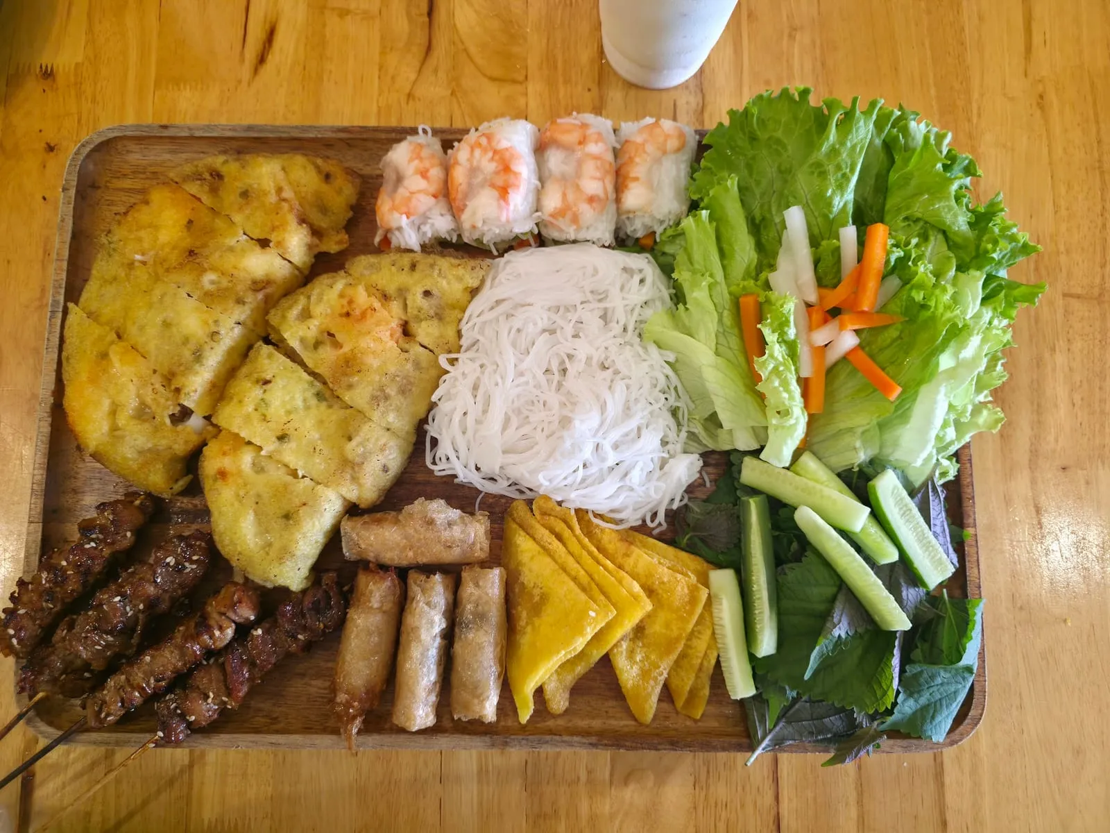 A spread of Vietnamese pancakes, grilled pork and fresh herbs at Banh Xeo Cuoi