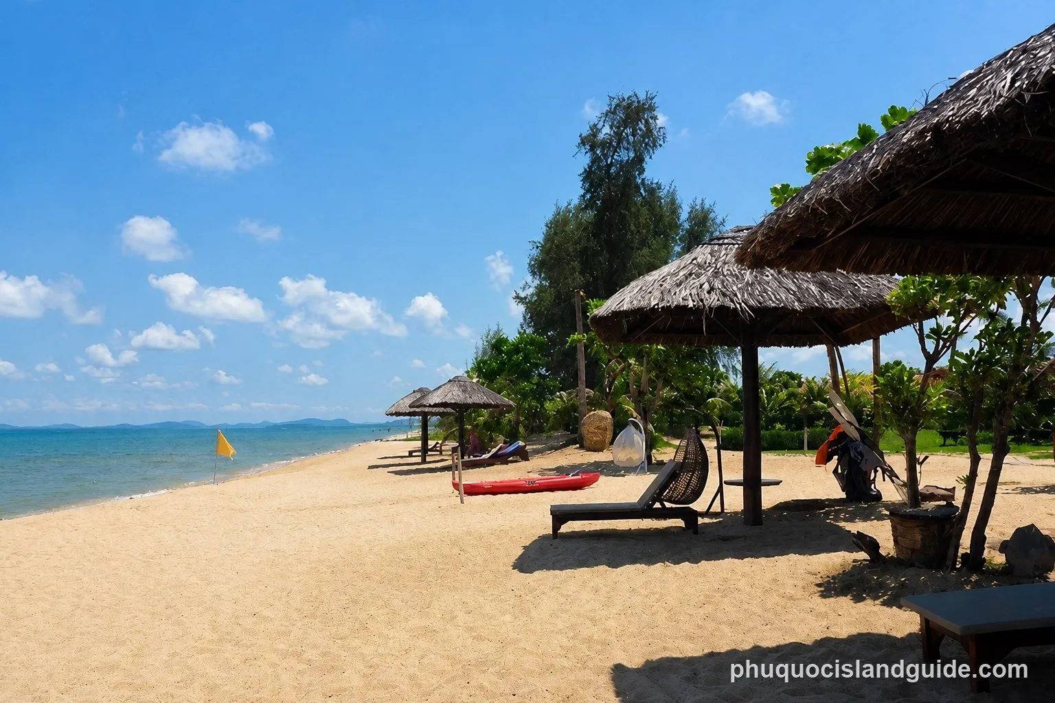 Thatched parasols, sunbeds and a red kayak on Long Beach